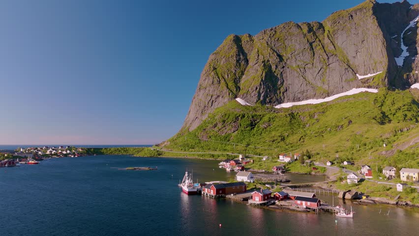 Discover the captivating beauty of Norway coastal village, where vibrant boats line the serene waters against a backdrop of stunning cliffs and lush greenery. Reine Lofoten