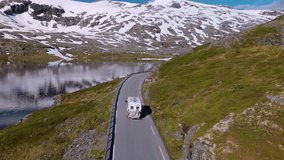 Experience the stunning beauty of Norway as a camper van navigates along a winding road surrounded by majestic snow-capped peaks and tranquil waters, showcasing natures splendor. - Powered by Shutterstock - Get 15% off with code: PIKWIZARD15