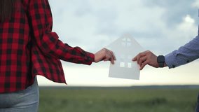 Couple holding paper house outdoors. Concept house green apartment. Hands holding paper house symbolize eco friendly living. Dream of house green apartment. Family planning green apartment lifestyle. - Powered by Shutterstock - Get 15% off with code: PIKWIZARD15