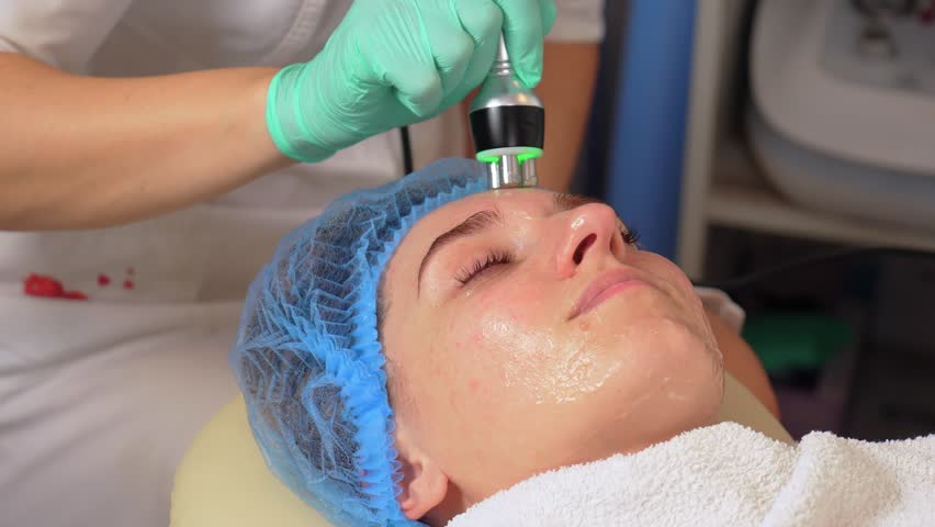 Close up of lifting anti aging therapy. Device for rejuvenation and anti aging facial skin in center of aesthetic cosmetology. Concept of skin care. Hardware ultrasound cosmetic procedure