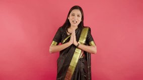 Lady standing delivers her speech with joined hands, Woman stands with palms pressed together while speaking, Female confidently talk, Respectful pose, Humble posture, Gesture of honor, Wearing saree - Powered by Shutterstock - Get 15% off with code: PIKWIZARD15