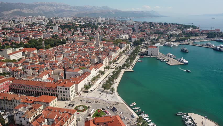 A beautiful view from Sveti Frane Church overlooking the vibrant Riva Promenade and Split on a sunny day. The Adriatic Sea and historic buildings create a picturesque scene.