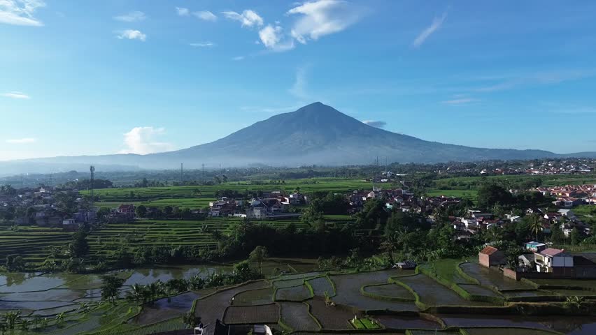 Beautiful view of Mount Cikuray in the morning, bathed in the warm glow of sunrise. Surrounded by lush greenery and misty clouds, this majestic mountain picturesque natural landscape