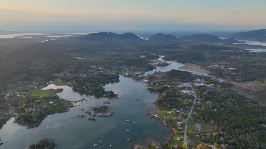 Bass Harbor and village aerial view at sunset with Mountains in Acadia National Park at the background in town of Tremont on Mt Desert Island, Maine ME, USA. 
