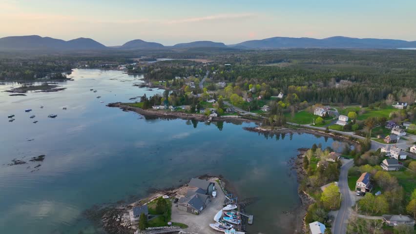 Bass Harbor and village aerial view at sunset with Mountains in Acadia National Park at the background in town of Tremont on Mt Desert Island, Maine ME, USA. 