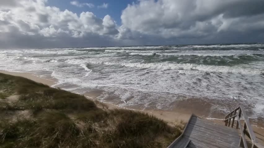 Wild fury of nature on the Curonian Spit. Hurricane winds and Baltic Sea waves reach the protective dune. View from the dune