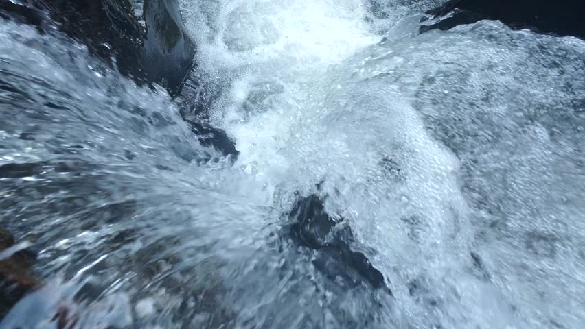 Close Up Of Cascading Water Flowing Down Stream In Slow Motion
