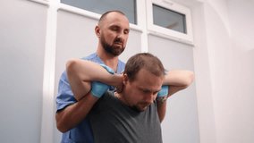 Neck manipulation, Manual therapy, Chiropractic healing. Male patient, seated with his hands behind his head, receives neck adjustment from chiropractor in blue scrubs and gloves. - Powered by Shutterstock - Get 15% off with code: PIKWIZARD15