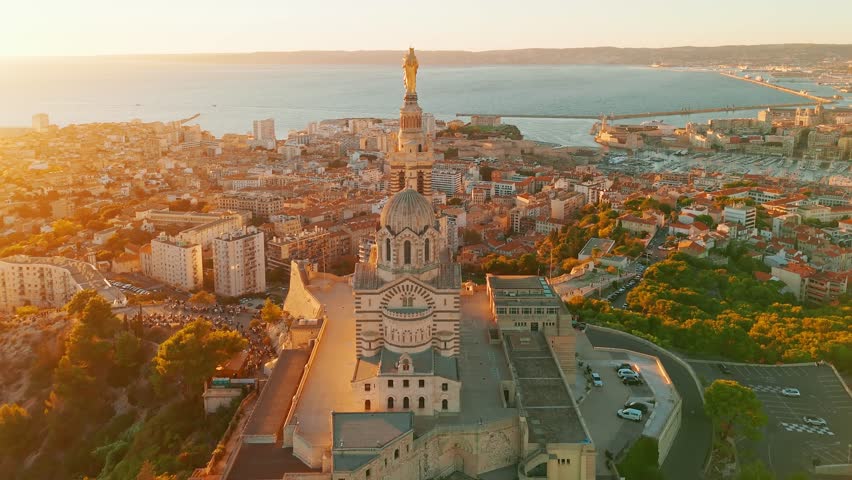 Aerial view of the Notre Dame de la Garde or Our Lady of the Guard church at sunset, southern France. The warm summer evening light illuminates the Marseille cityscape. 