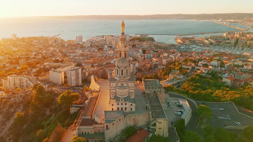 Aerial view of the Notre Dame de la Garde or Our Lady of the Guard church at sunset, southern France. The warm summer evening light illuminates the Marseille cityscape. 