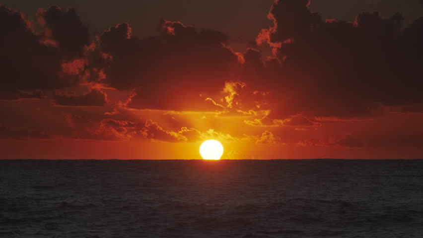 Vibrant sunset over ocean with dramatic clouds at dusk, 4k