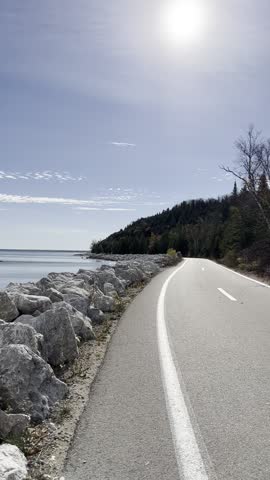 Scenic walk along lake water blue sky green trees Mackinac Island, Michigan
