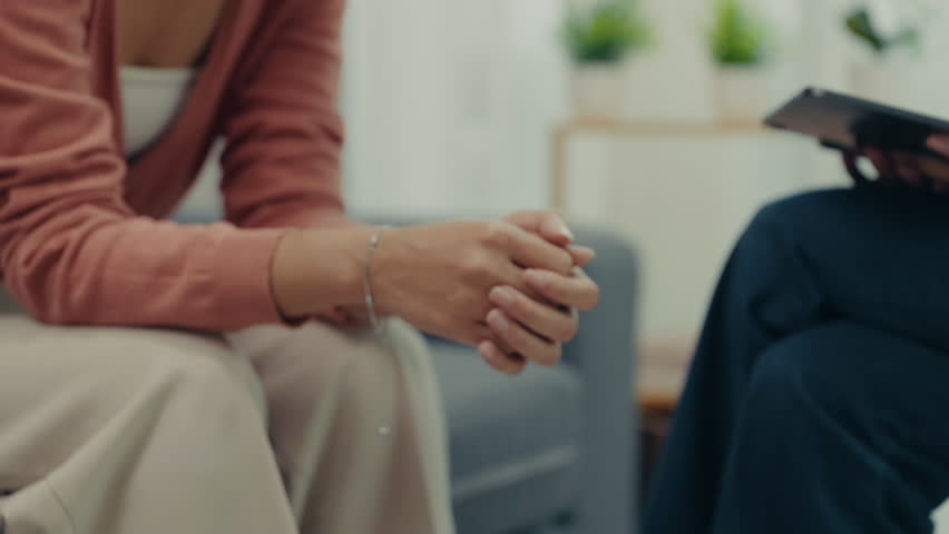 A woman holds hands tightly during a counseling session, symbolizing emotional support, trust, and guidance while discussing relationship struggles with a therapist.
