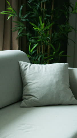 Vertical video. A close-up shot of a hand gripping a bundle of banknotes set against a blurred indoor background. Financial abundance, investment, and prosperity.