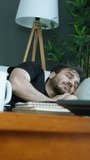 Vertical video. A young man suddenly wakes up from his sleep, looks around with a confused expression, and then settles back down to sleep. Momentary disorientation before returning to rest. - Powered by Shutterstock - Get 15% off with code: PIKWIZARD15