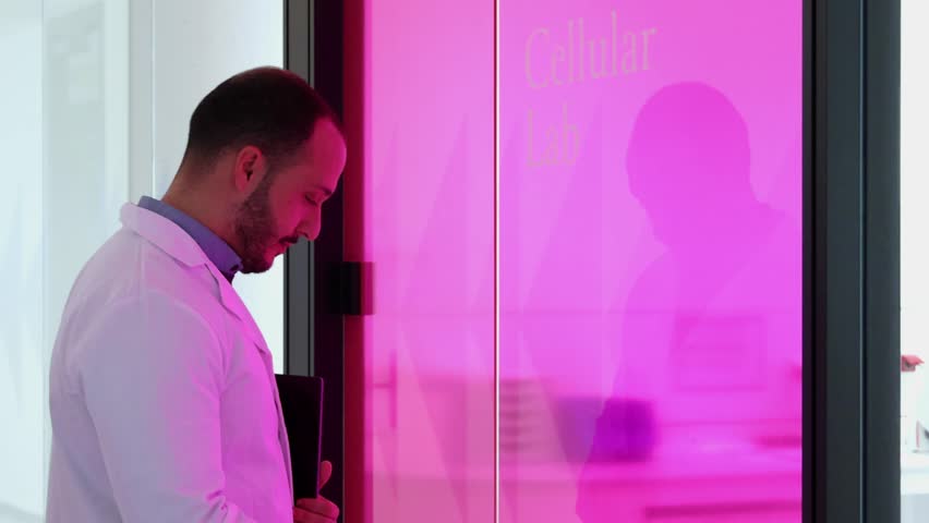 Research scientists navigating modern hallway, accessing advanced cellular laboratory through magenta-colored glass door using electronic key card, embodying scientific innovation