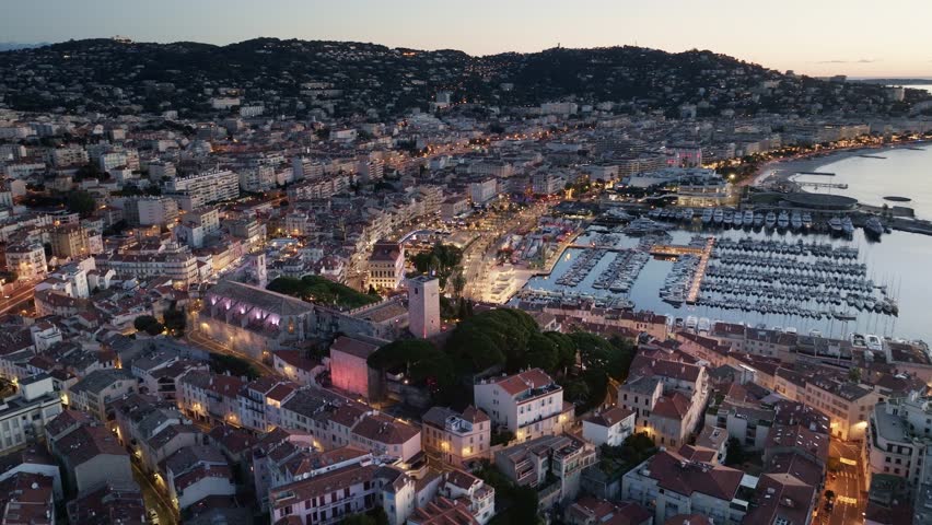 Cannes aerial view at sunset, famous resort on the French Riviera, the city of Cannes film festival, Cannes harbour with luxury yachts from a drone. 