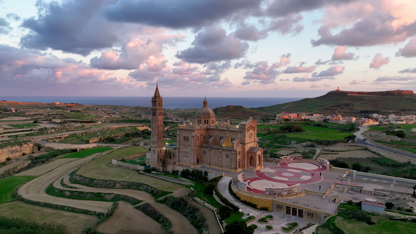 Aerial view of Stunning view of a illuminated Basilica of Our Lady of Ta' Pinu on a hilltop with dramatic sky and landscape. Gozo. Malta