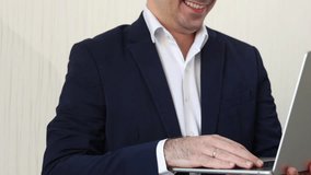 man in business suit is working on laptop sitting against wall.unrecognizable businessman or freelancer typing on keyboard or having a video call. remote job concept.busy worker in office - Powered by Shutterstock - Get 15% off with code: PIKWIZARD15