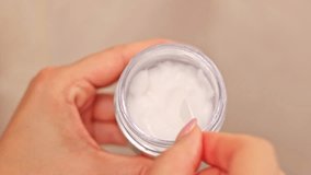 woman doing daily face and skin routine in bathroom.girl in bathrobe looking in mirror,applying facial cream or lotion on hand, taking from jar with spoon,putting serum on neck and chest. - Powered by Shutterstock - Get 15% off with code: PIKWIZARD15