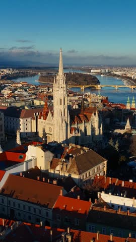 Vertical video: flying above Budapest Castle hill at sunset, drone shot of Trinity Square in Budapest, capital of Hungary, tourism in Hungary. 