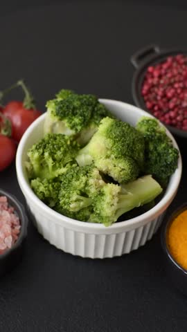 Delicious fresh green broccoli steamed in a ceramic plate on a textured concrete background