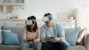 In a cozy living room, a young couple engages in a virtual reality gaming session, wearing headsets and holding game controllers while seated on a comfortable sofa. - Powered by Shutterstock - Get 15% off with code: PIKWIZARD15
