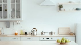 A couple stands in a bright, modern kitchen, smiling as they unpack groceries from paper bags. Fresh produce and other items fill their hands, creating a warm, collaborative atmosphere. - Powered by Shutterstock - Get 15% off with code: PIKWIZARD15