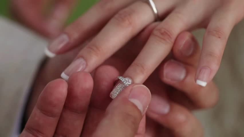 Closeup man hand putting ring on girls finger. Bride and groom exchanging wedding rings in wedding ceremony. matrimony details. Church tradition