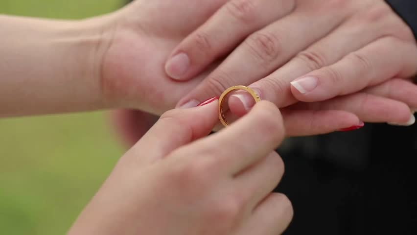 exchanged wedding rings. at the weddings ceremony. Groom puts the wedding ring on Bride. The bride puts the matrimony ring on the groom's finger.