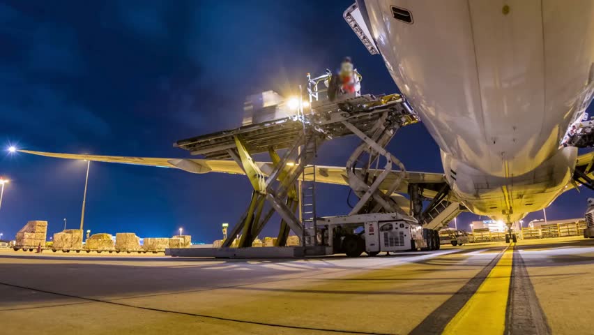 aircraft on runway at night. Low angle photo of freight airplane at airport. Commercial cargo air freight airplane loaded at airport at night. Airplane parked at airport, low angle view.