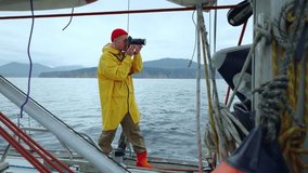 Male Tourist In Yellow Raincoat Taking Photo By Professional Camera From Deck Of Boat - Powered by Shutterstock - Get 15% off with code: PIKWIZARD15