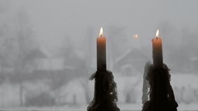 Snowfall outside the window. The flickering flames cast a gentle light bringing comfort to the house. A winter snowstorm rages outside the countryside window.  - Powered by Shutterstock - Get 15% off with code: PIKWIZARD15