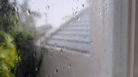A detailed closeup of water droplets clinging to a glass pane, with the outside view reduced to a blurred abstract of colors and shapes. The condensation and droplets create intricate patterns - Powered by Shutterstock - Get 15% off with code: PIKWIZARD15
