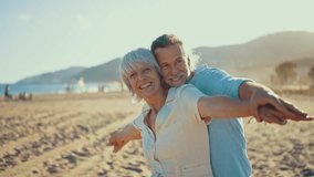 Beautiful happy senior couple dating at the seaside during summertime - Mature married couple in love bonding outdoors at the beach, concepts about elderly lifestyle, relationship and quality of life - Powered by Shutterstock - Get 15% off with code: PIKWIZARD15