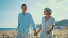 Beautiful happy senior couple dating at the seaside during summertime - Mature married couple in love bonding outdoors at the beach, concepts about elderly lifestyle, relationship and quality of life - Powered by Shutterstock - Get 15% off with code: PIKWIZARD15