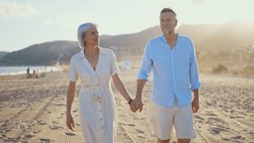 Beautiful happy senior couple dating at the seaside during summertime - Mature married couple in love bonding outdoors at the beach, concepts about elderly lifestyle, relationship and quality of life - Powered by Shutterstock - Get 15% off with code: PIKWIZARD15