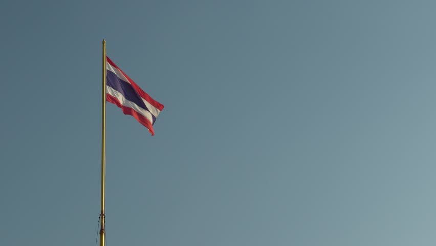 Thailand flag on pole waving in the wind sky background. The national flag of Thailand