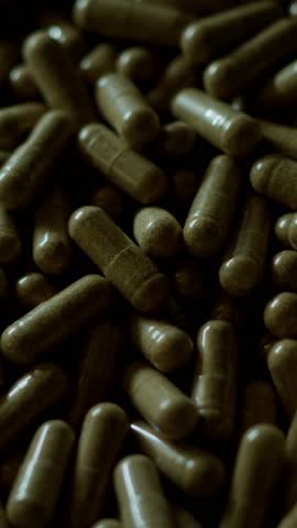 A close-up shot of supplement capsules with soft light moving across the surface. The video highlights the texture and form of the capsules, creating a clean and pharmaceutical aesthetic.