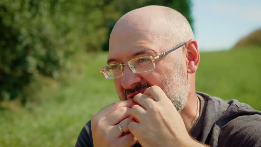 Bearded man eating sour lemon and reacting with puckered face. Male tasting lemon slice and expressing tangy discomfort. Guy trying citrus fruit with amusing facial reaction