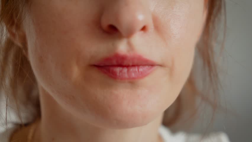 Unrecognizable woman eating and chewing dumplings. Female savoring food with close-up focus on lips. Lady enjoying meal in detailed and intimate dining moment