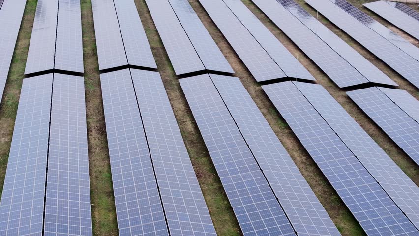 Drone glides of solar panels, revealing detailed view of renewable energy fields