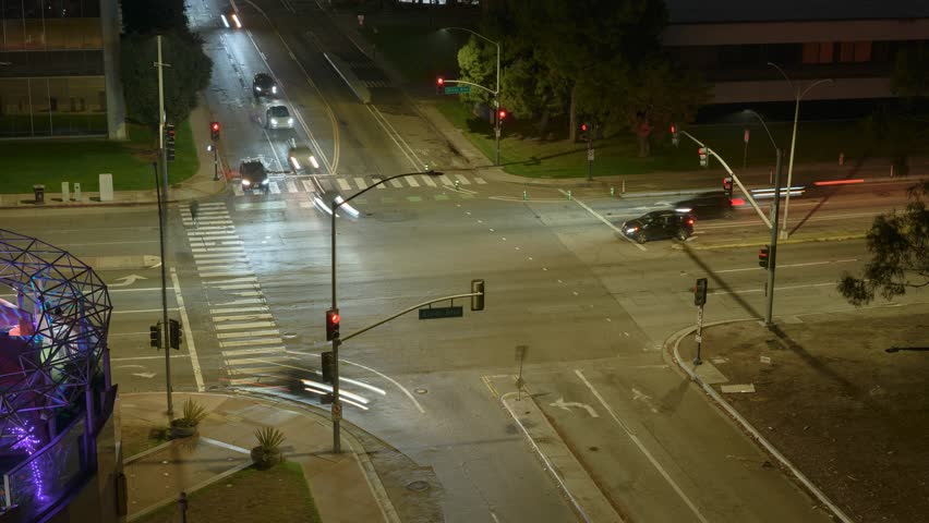 A busy nighttime timelapse of a Long Beach intersection with vibrant streetlights