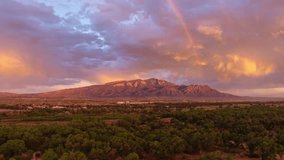 Epic aerial drone shot of the Sandia mountains with rainbow at sunset in New Mexico with the Rio Grande River with blue skies and puffy white clouds perfect sunny summer day cinematic establishing - Powered by Shutterstock - Get 15% off with code: PIKWIZARD15