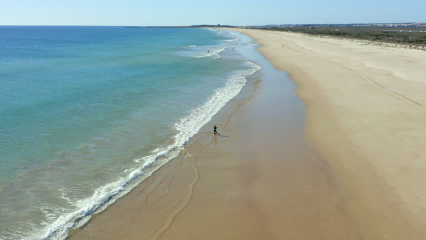 Drone flying backwards revealing a scenic beach landscape, Terra Estreita beach, Algarve