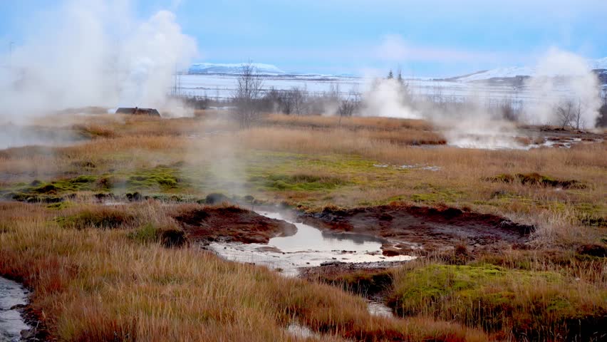 Small geysers of boiling water and steam in the volcanic geothermal area with erupting geysers of the Strokkur geothermal area in the Haukadalur volcanic system in Iceland