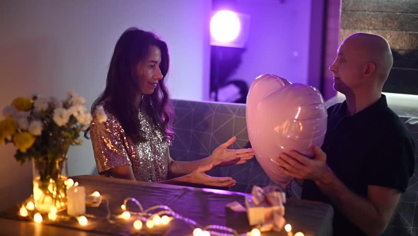 Romantic Anniversary love couple holding heart shaped balloon, celebrating valentine