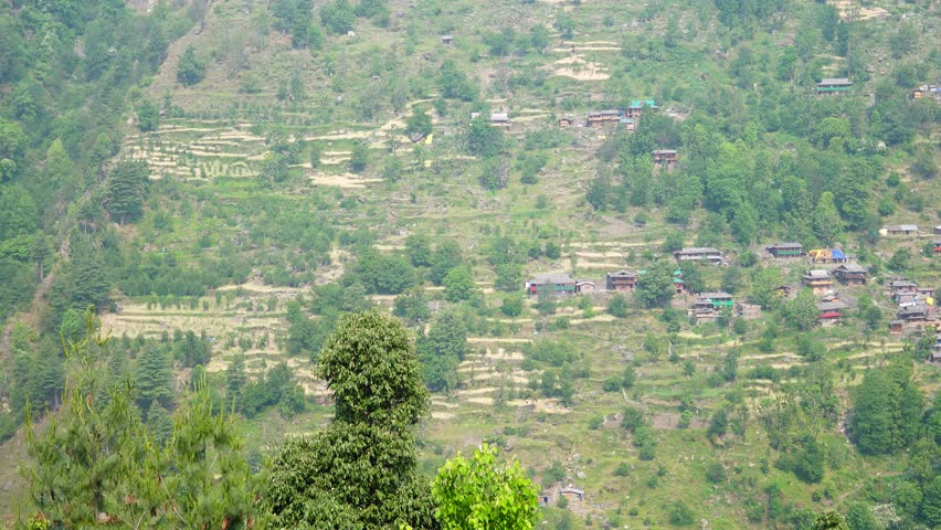 View of a mountain in the distance with houses nestled amidst the greenery there