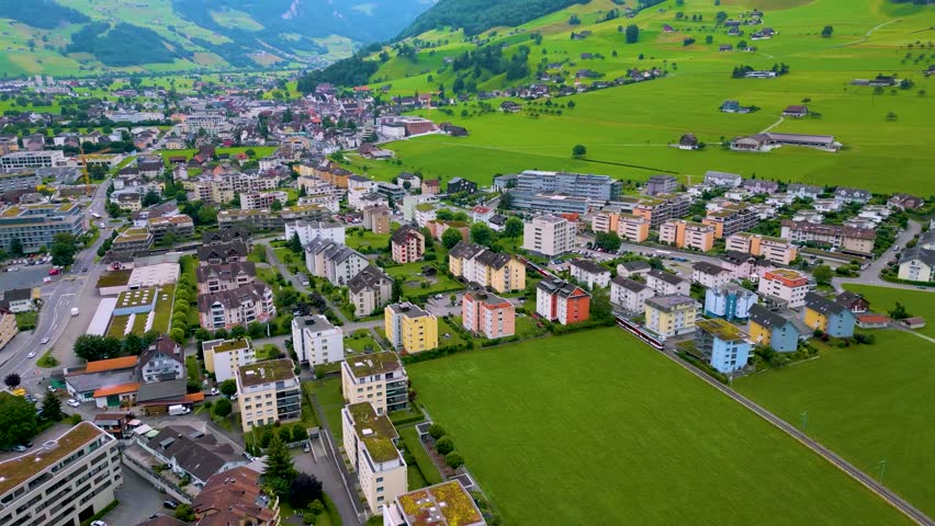 4K Drone Video of Train Passing Through a Village at the base of Stanserhorn Mountain in Stans, Switzerland