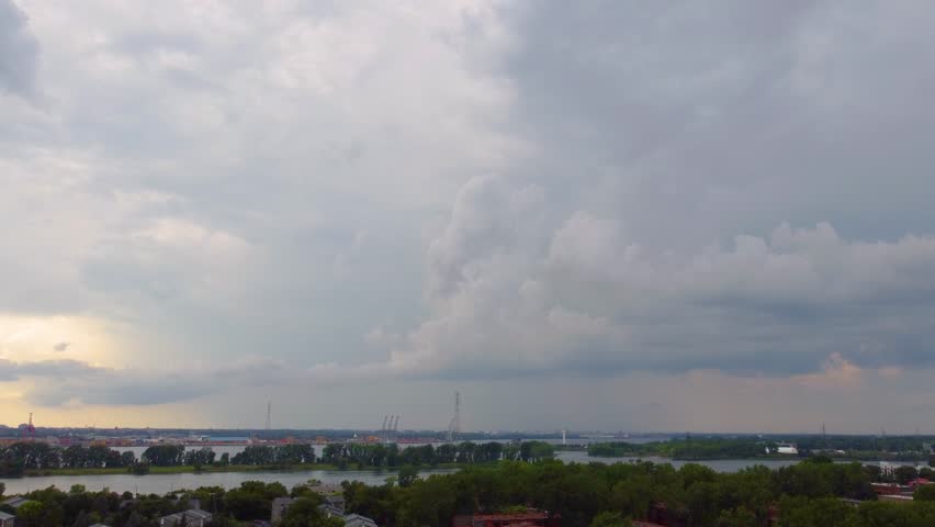 Breathtaking view of Sherbrooke, Québec, with dramatic Estrie skyline under moody, overcast cloudy skies.